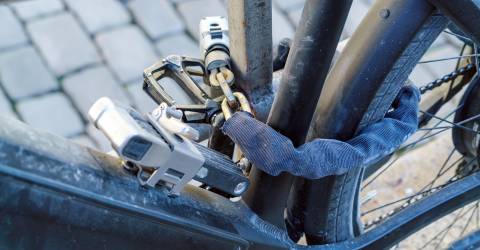 e-bike vastgelegd aan ijzeren paal met diverse sterke kettingen en sloten